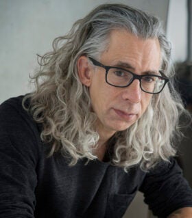 Headshot of Bret Anthony Johnston in black shirt with grey background